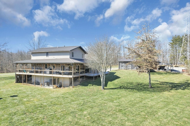 back of house featuring a lawn, metal roof, and a deck