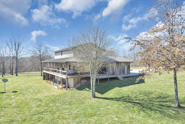 rear view of house featuring a wooden deck and a yard