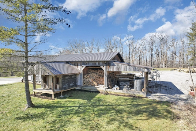 view of property exterior featuring an outbuilding, a lawn, and metal roof