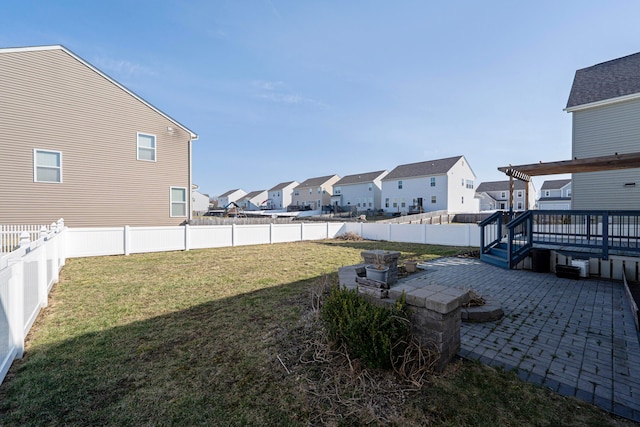 view of yard with a patio, a fenced backyard, a residential view, and a wooden deck