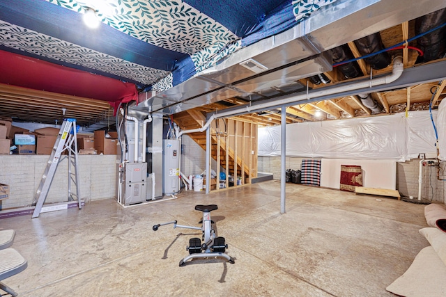 unfinished basement with stairway, heating unit, water heater, and brick wall