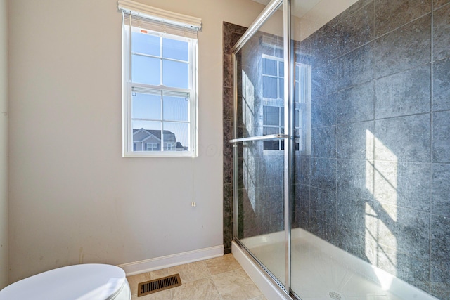 bathroom featuring visible vents, toilet, a shower stall, tile patterned flooring, and baseboards