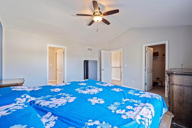 bedroom featuring a spacious closet, visible vents, ceiling fan, lofted ceiling, and carpet floors