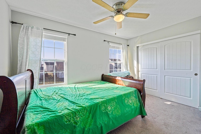 bedroom with a closet, carpet floors, and a ceiling fan