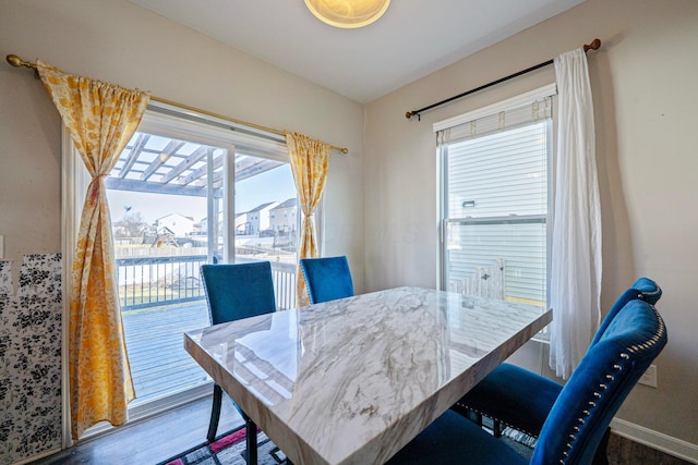 dining space featuring baseboards and wood finished floors