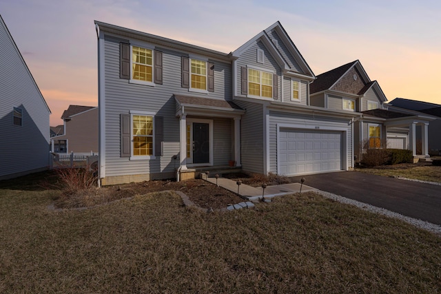 view of front of house featuring a garage, a yard, driveway, and fence