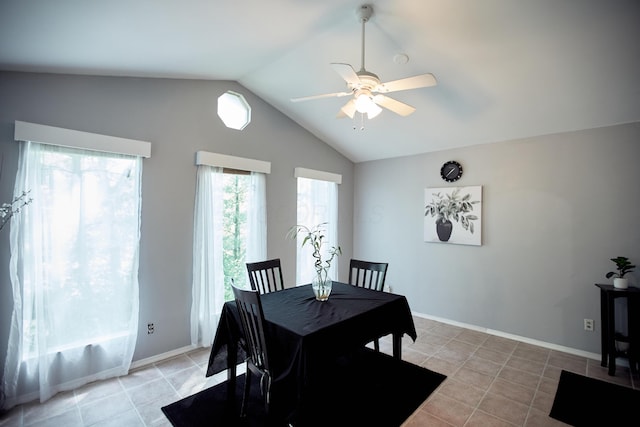 dining space featuring lofted ceiling, light tile patterned floors, a ceiling fan, and baseboards