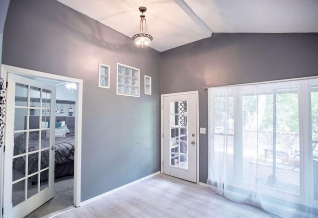 interior space with baseboards, wood finished floors, and vaulted ceiling