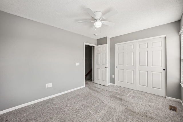 unfurnished bedroom featuring visible vents, a textured ceiling, a closet, carpet floors, and baseboards