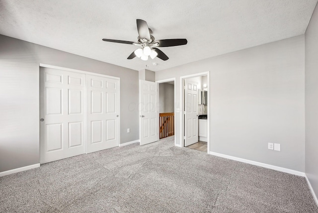 unfurnished bedroom with a closet, baseboards, light colored carpet, and a textured ceiling