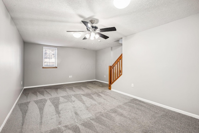 empty room featuring stairway, carpet floors, baseboards, and a ceiling fan