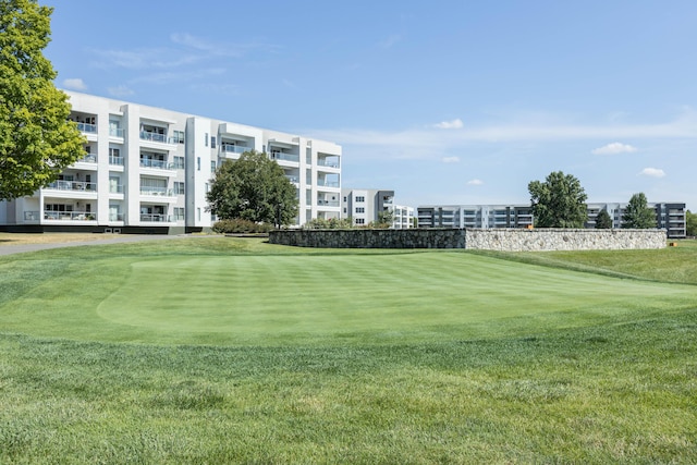 view of home's community with golf course view and a lawn