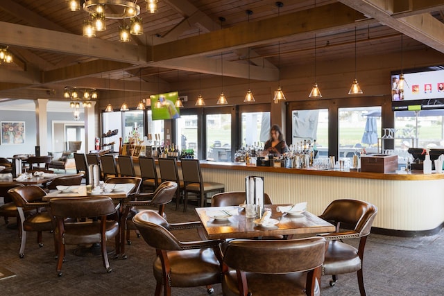 dining room featuring a notable chandelier, wooden ceiling, vaulted ceiling with beams, and carpet floors