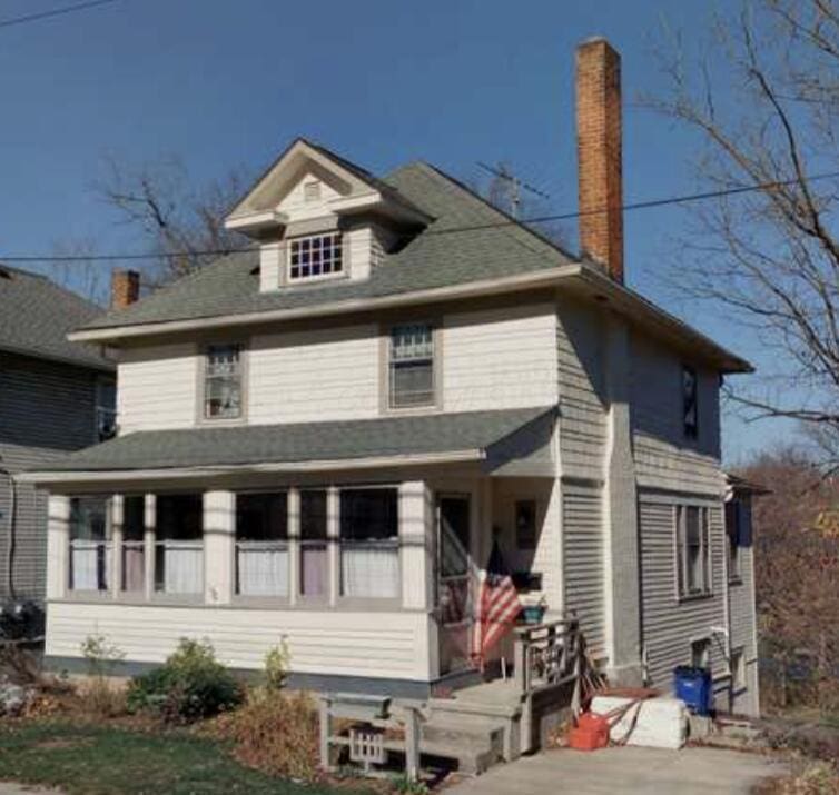 american foursquare style home featuring a chimney