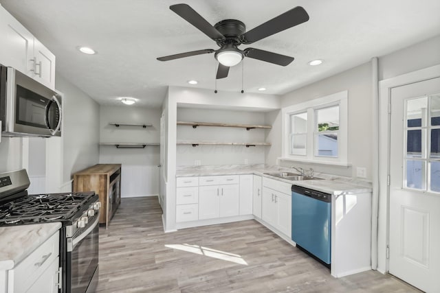 kitchen with open shelves, light wood-style floors, appliances with stainless steel finishes, and a sink