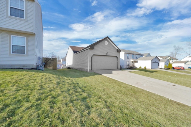 view of side of property with a garage, concrete driveway, a yard, and a residential view