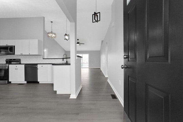 kitchen with decorative backsplash, dark countertops, white cabinetry, and appliances with stainless steel finishes