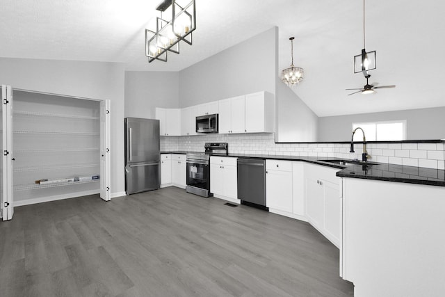 kitchen featuring a sink, dark countertops, ceiling fan with notable chandelier, and stainless steel appliances