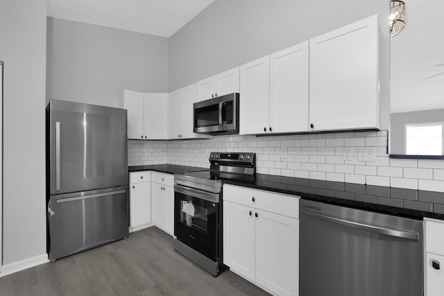 kitchen with white cabinetry, backsplash, dark wood-style floors, and appliances with stainless steel finishes