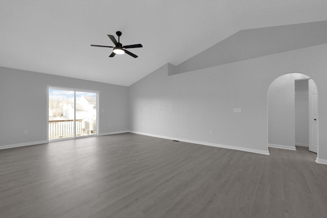 unfurnished room with baseboards, dark wood finished floors, lofted ceiling, arched walkways, and ceiling fan