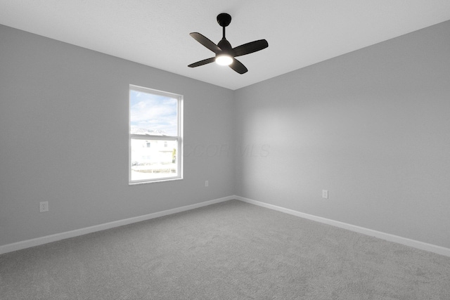 carpeted empty room featuring a ceiling fan and baseboards