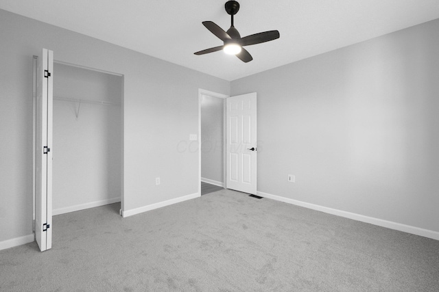 unfurnished bedroom with baseboards, carpet floors, a closet, and ceiling fan