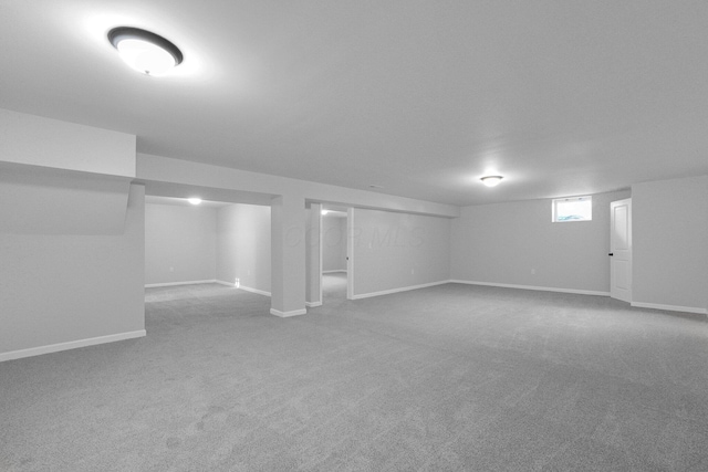 below grade area with baseboards and carpet flooring