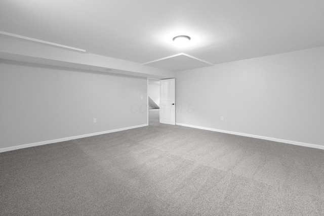 unfurnished room with baseboards and dark colored carpet