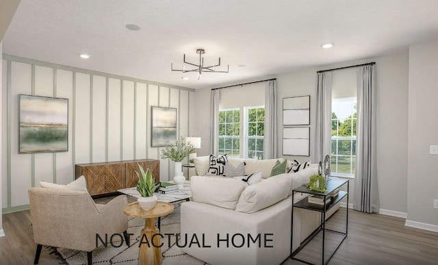 living area with recessed lighting, a textured ceiling, baseboards, and wood finished floors