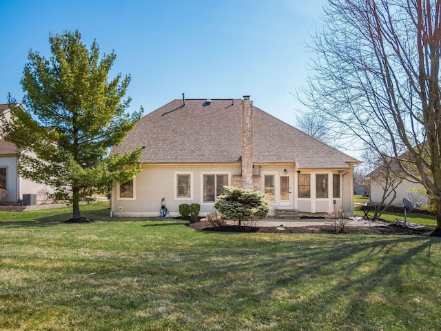 rear view of house featuring entry steps, cooling unit, a lawn, and roof with shingles