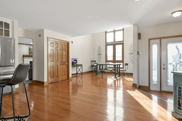 entryway with a fireplace, baseboards, and wood-type flooring