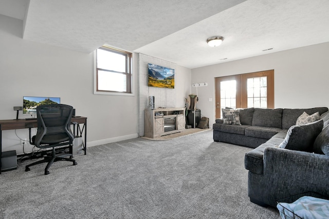 living area featuring carpet flooring, a textured ceiling, and baseboards