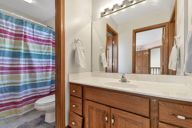 bathroom featuring tile patterned flooring, curtained shower, toilet, and vanity