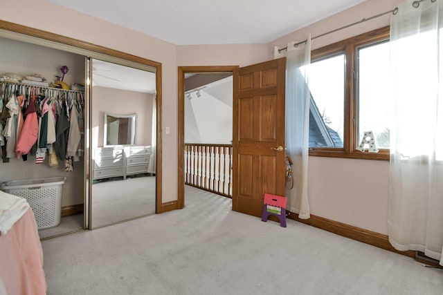 bedroom featuring light colored carpet, a closet, and baseboards