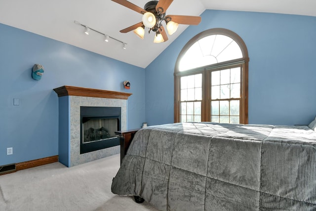 bedroom featuring visible vents, baseboards, lofted ceiling, carpet floors, and a tile fireplace