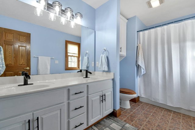 bathroom with double vanity, visible vents, toilet, and a sink