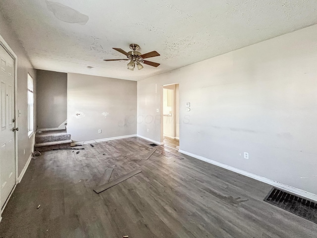 unfurnished living room with visible vents, baseboards, ceiling fan, wood finished floors, and a textured ceiling