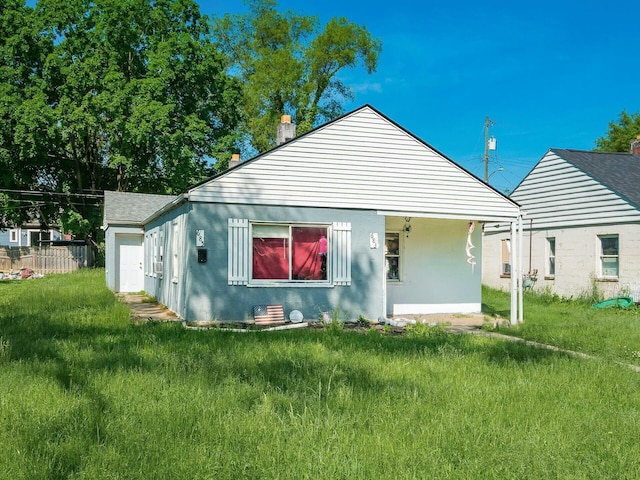 rear view of house with a yard, fence, a garage, and stucco siding