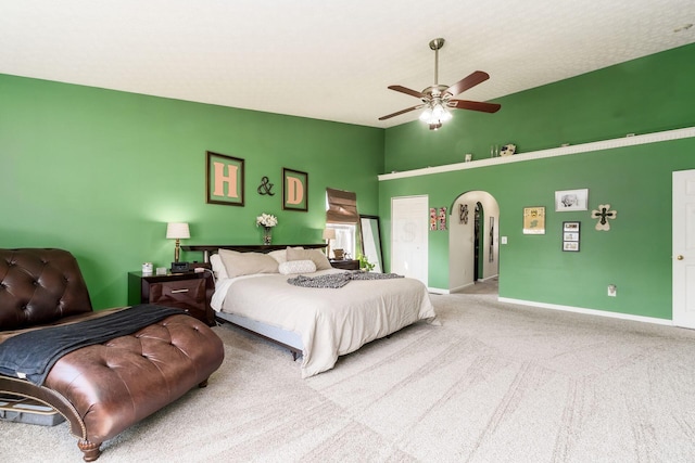 bedroom with baseboards, lofted ceiling, carpet flooring, arched walkways, and a ceiling fan