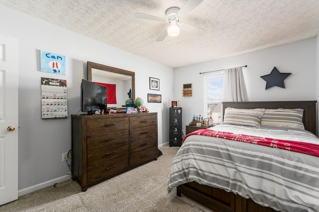 bedroom with light carpet, a textured ceiling, and baseboards