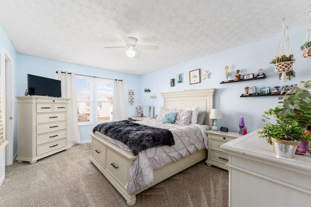 bedroom with a ceiling fan, light colored carpet, and a textured ceiling