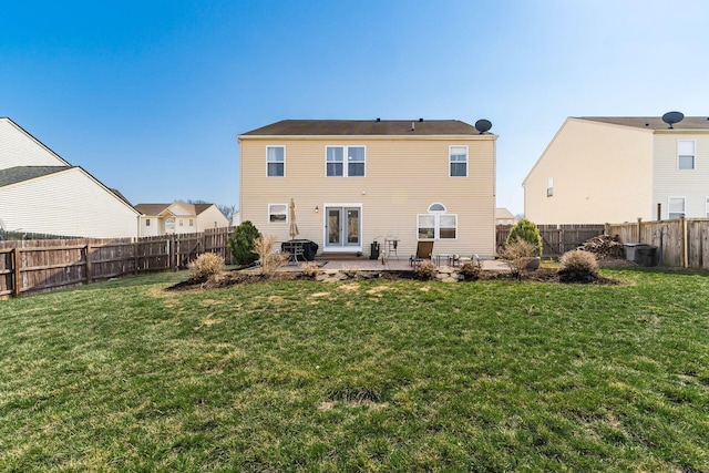 rear view of house with a yard, a fenced backyard, and a patio area