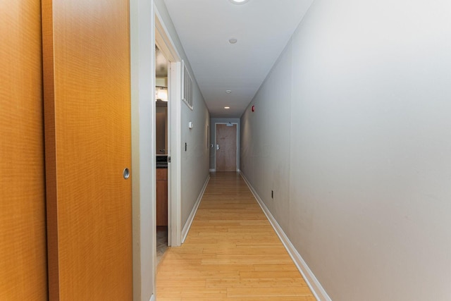 hall featuring recessed lighting, light wood-type flooring, and baseboards