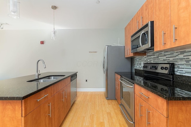 kitchen with a sink, stainless steel appliances, backsplash, and brown cabinetry