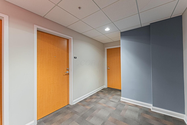 carpeted empty room with recessed lighting, a drop ceiling, and baseboards