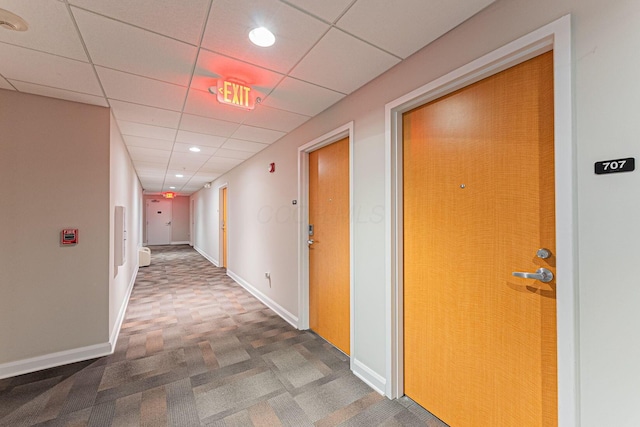 hall featuring a drop ceiling, recessed lighting, baseboards, and carpet floors