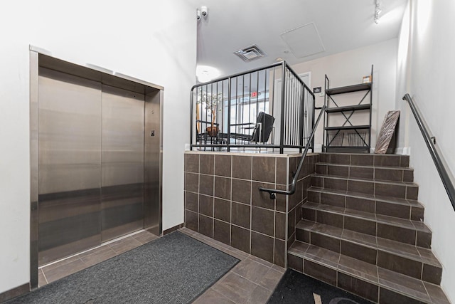 interior space featuring tile patterned floors, visible vents, elevator, and tiled shower