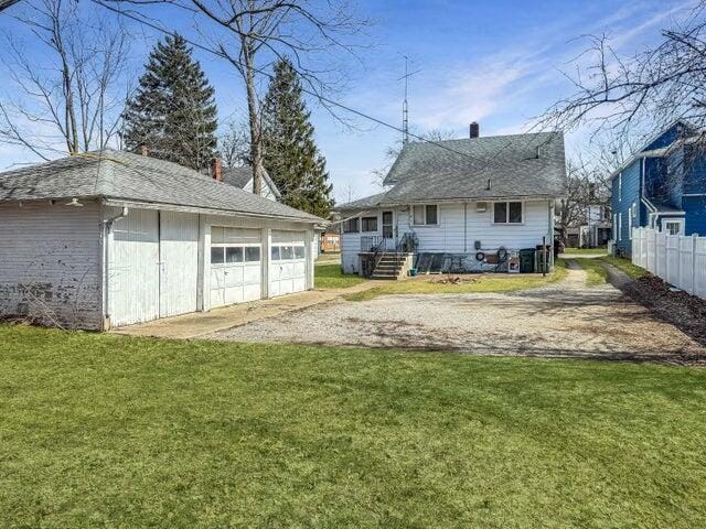 812 S Main St, Urbana, OH 43078 - back of property with fence, a lawn, a chimney, a garage, and an outbuilding