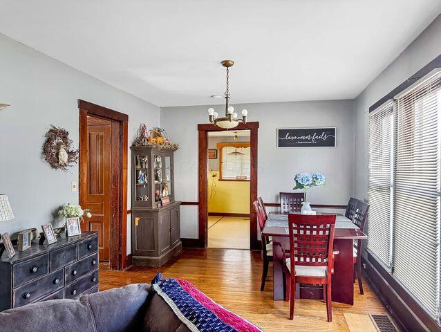 812 S Main St, Urbana, OH 43078 - dining space featuring a notable chandelier, wood finished floors, visible vents, and baseboards