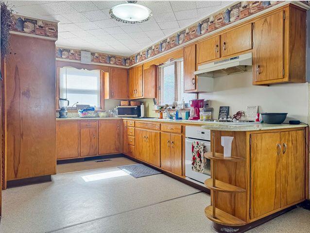 812 S Main St, Urbana, OH 43078 - kitchen with under cabinet range hood, a healthy amount of sunlight, and light countertops